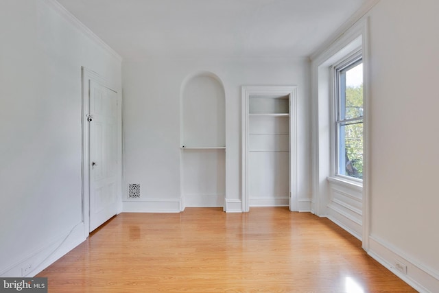 empty room featuring ornamental molding and light hardwood / wood-style floors