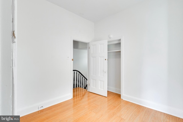 unfurnished bedroom with a closet and light hardwood / wood-style floors