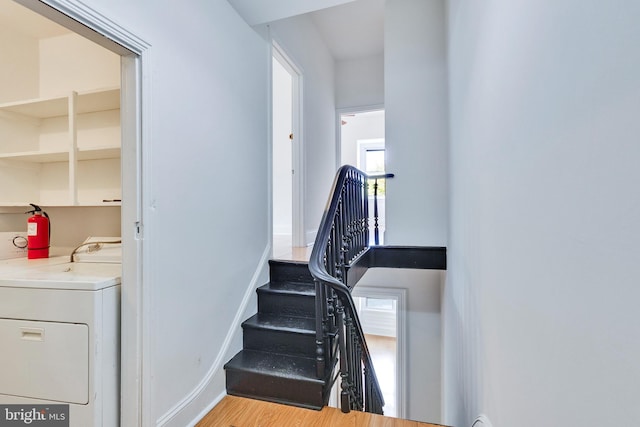 staircase with washer / clothes dryer, plenty of natural light, and hardwood / wood-style floors