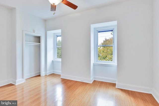 unfurnished bedroom with a closet, light wood-type flooring, and ceiling fan