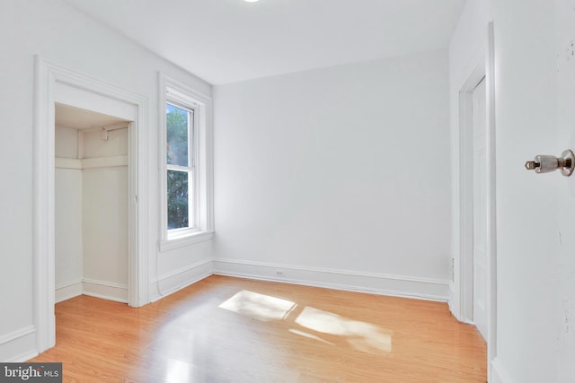 unfurnished bedroom with a closet and light wood-type flooring