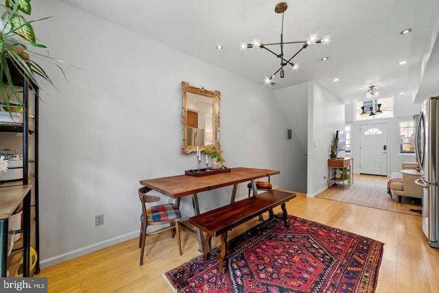 dining space with an inviting chandelier and light hardwood / wood-style floors