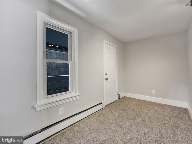 spare room featuring baseboard heating and carpet floors