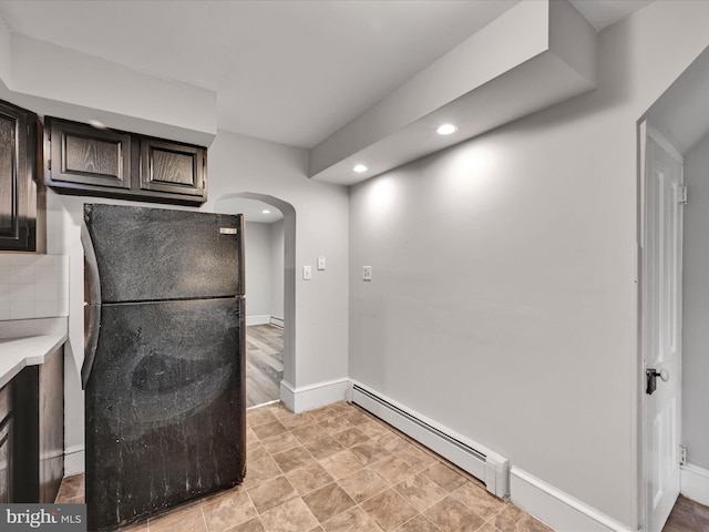 kitchen featuring black fridge, a baseboard radiator, and dark brown cabinets