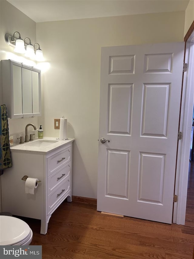 bathroom with vanity, hardwood / wood-style floors, and toilet