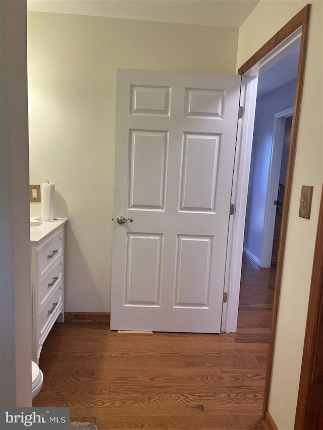 bathroom featuring vanity, hardwood / wood-style flooring, and toilet