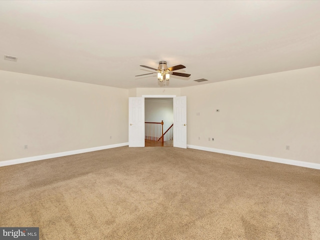 unfurnished room featuring ceiling fan and carpet