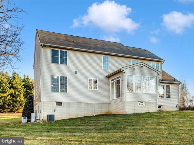 rear view of house featuring a yard and cooling unit