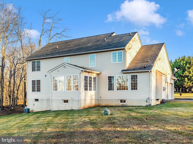 back of house featuring central AC, a yard, and a garage