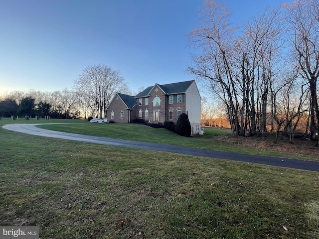 property exterior at dusk with a yard