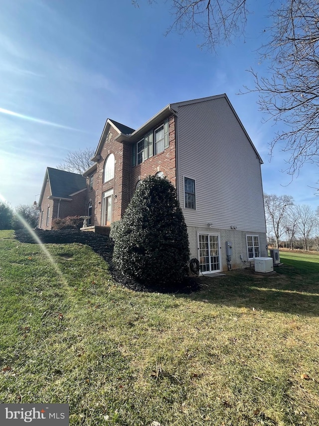 view of property exterior with central air condition unit and a yard