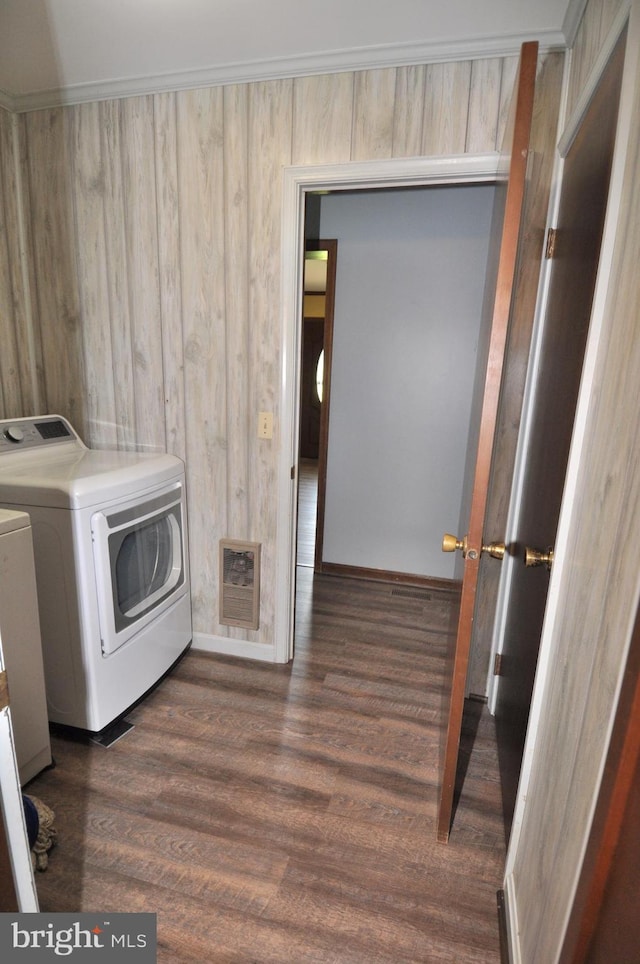 clothes washing area with wood walls, dark wood-type flooring, and washing machine and clothes dryer