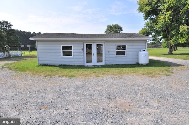 view of front of home with french doors and a front lawn