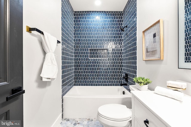 full bathroom featuring tiled shower / bath, vanity, toilet, and tile patterned floors