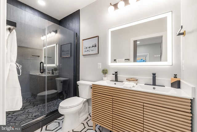 bathroom with a shower with shower door, vanity, and toilet