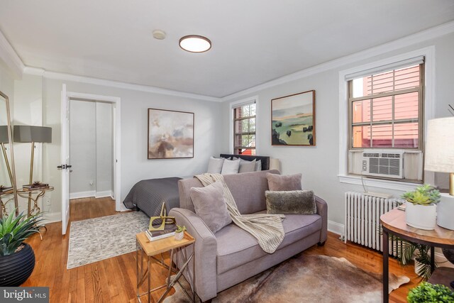 living room with radiator heating unit, ornamental molding, and hardwood / wood-style flooring