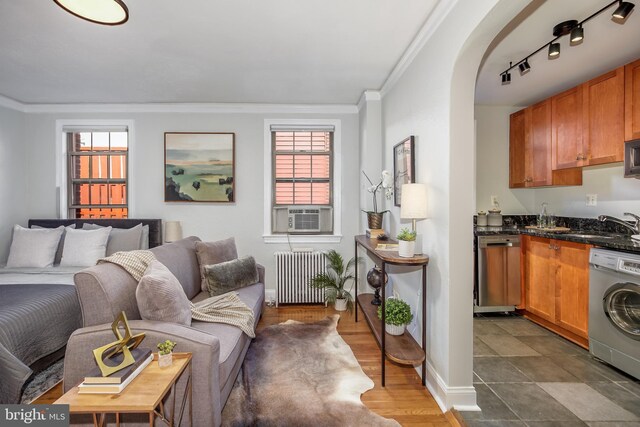 interior space featuring ornamental molding, cooling unit, sink, washer / dryer, and radiator