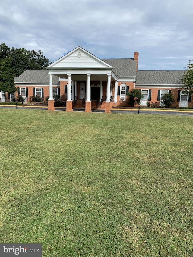 neoclassical home featuring covered porch and a front yard