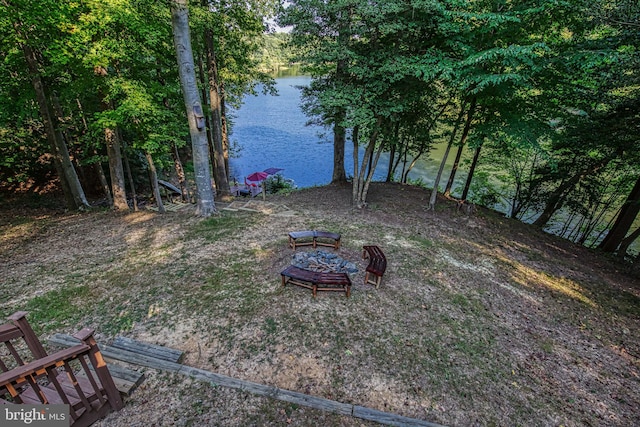 view of yard featuring a water view and an outdoor fire pit