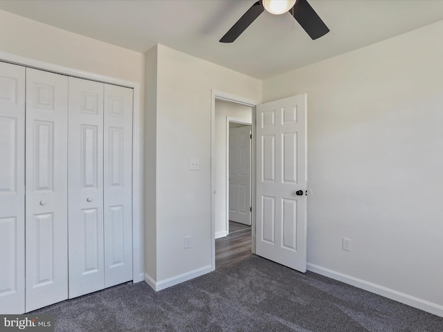 unfurnished bedroom featuring dark carpet, a closet, and ceiling fan