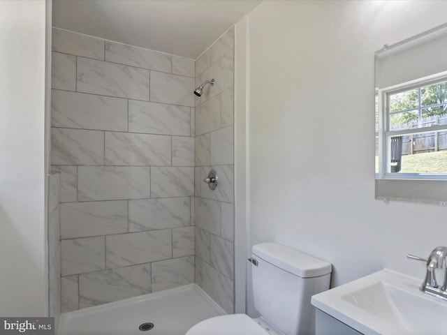 bathroom featuring tiled shower, vanity, and toilet