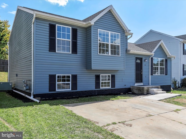 view of front of property featuring a patio area, a front lawn, and cooling unit