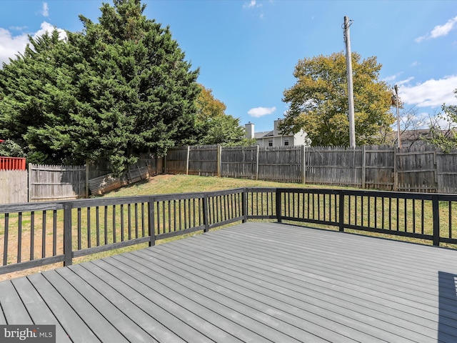 wooden terrace featuring a lawn and a fenced backyard