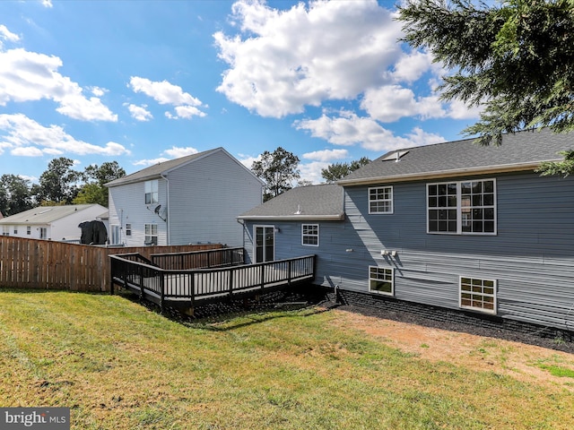 rear view of property featuring a lawn and a wooden deck