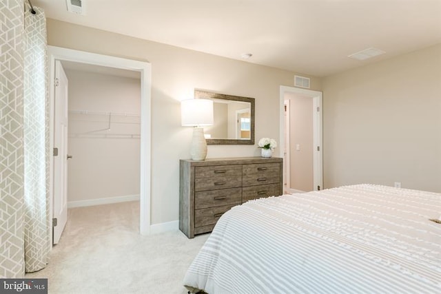 carpeted bedroom with a spacious closet and a closet