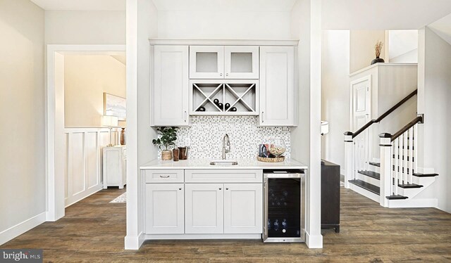 bar with white cabinets, wine cooler, dark wood-type flooring, and sink