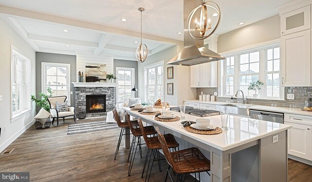 kitchen featuring beamed ceiling, white cabinetry, dark hardwood / wood-style floors, a center island, and a fireplace