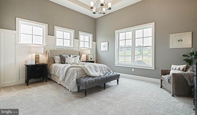 carpeted bedroom featuring a high ceiling and a notable chandelier