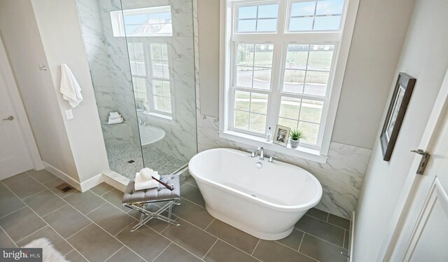 bathroom featuring tile walls, tile patterned flooring, and plus walk in shower