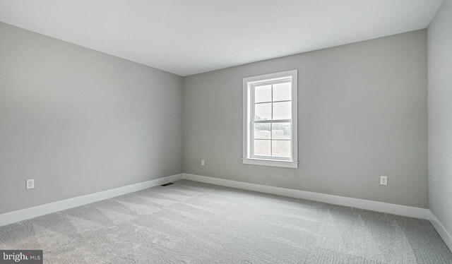 unfurnished room featuring light carpet