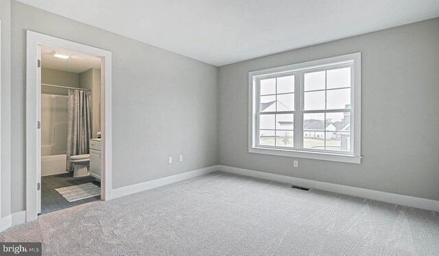 unfurnished bedroom featuring connected bathroom and carpet flooring