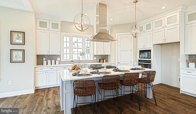 kitchen featuring a center island, white cabinets, island exhaust hood, an inviting chandelier, and stainless steel oven