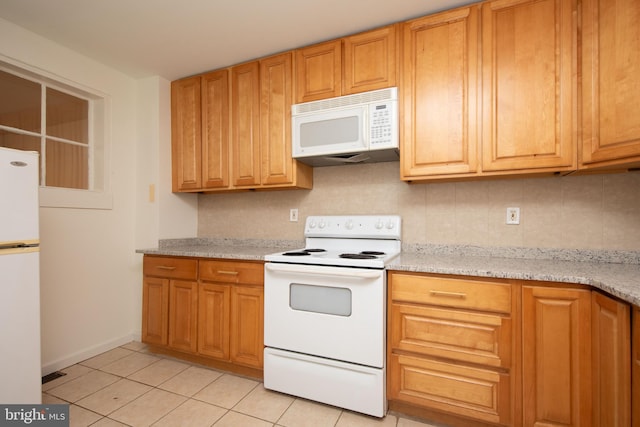 kitchen with white appliances, light stone counters, light tile patterned floors, and tasteful backsplash