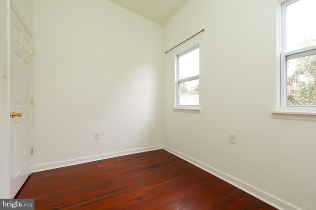 empty room with dark hardwood / wood-style flooring