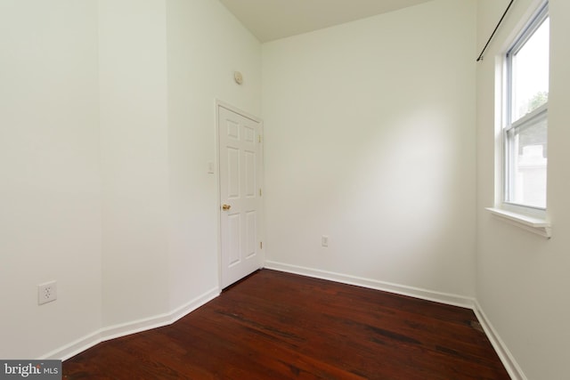 unfurnished room with plenty of natural light and dark wood-type flooring