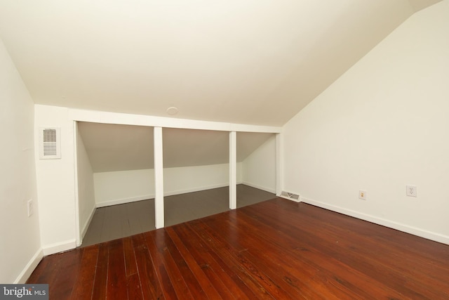 unfurnished bedroom with vaulted ceiling and dark hardwood / wood-style floors