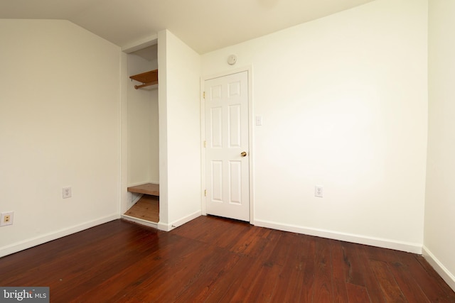 unfurnished bedroom featuring dark hardwood / wood-style floors and vaulted ceiling