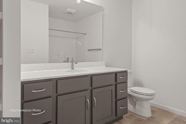 bathroom with vanity, a shower, tile patterned flooring, and toilet