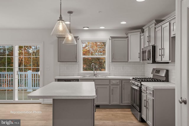 kitchen with pendant lighting, stainless steel appliances, a healthy amount of sunlight, and sink