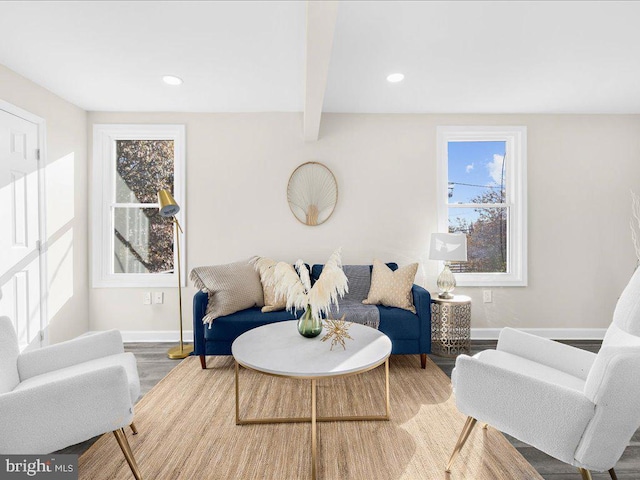 living room featuring beamed ceiling, hardwood / wood-style flooring, and plenty of natural light