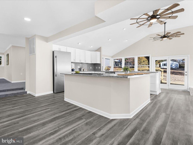 kitchen featuring white cabinetry, stainless steel refrigerator, dark hardwood / wood-style floors, and a center island