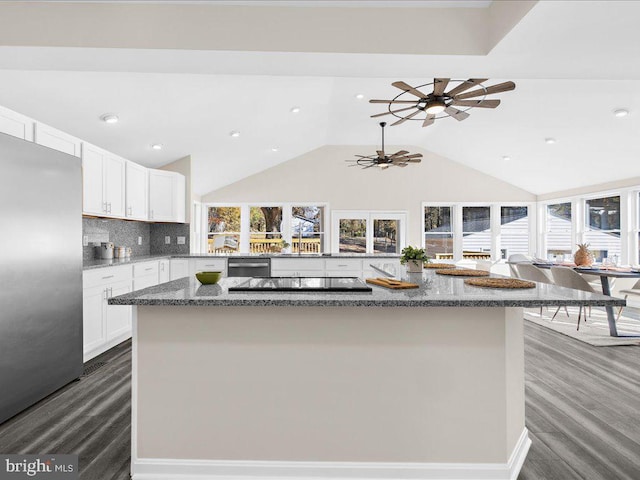 kitchen with white cabinetry, appliances with stainless steel finishes, lofted ceiling, and dark hardwood / wood-style floors