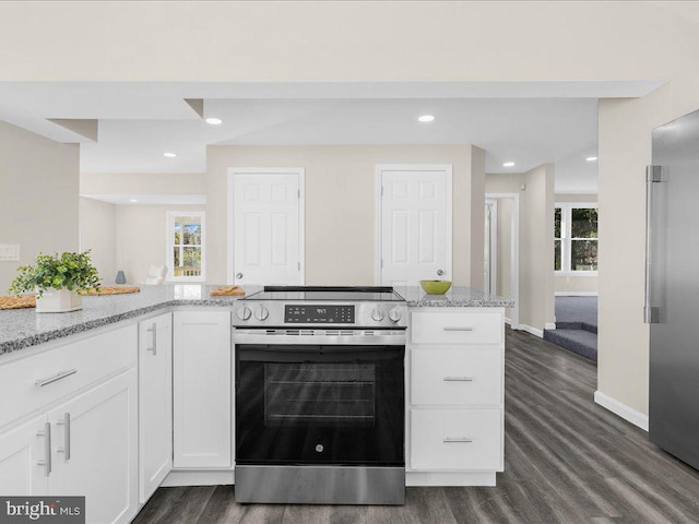 kitchen featuring dark hardwood / wood-style flooring, white cabinets, light stone counters, and stainless steel appliances