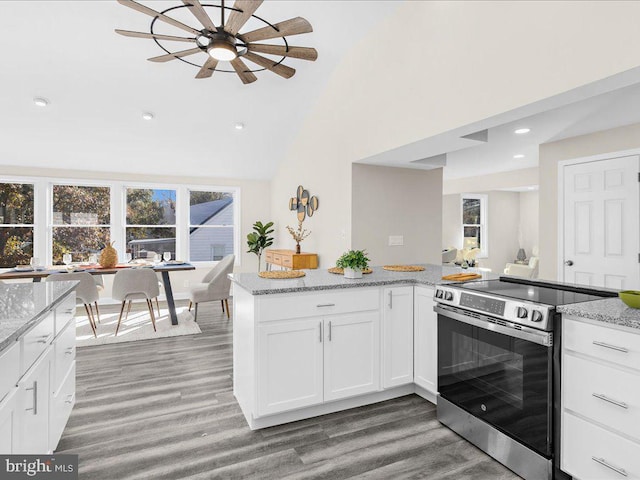 kitchen featuring stainless steel electric range, dark hardwood / wood-style flooring, light stone countertops, white cabinets, and ceiling fan