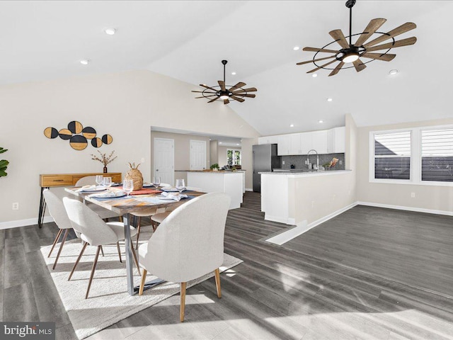 dining area with sink, ceiling fan, vaulted ceiling, and dark hardwood / wood-style floors