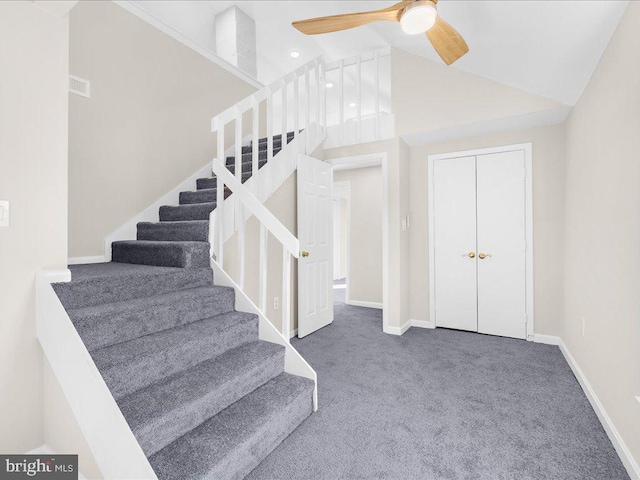 staircase with high vaulted ceiling, carpet flooring, and ceiling fan